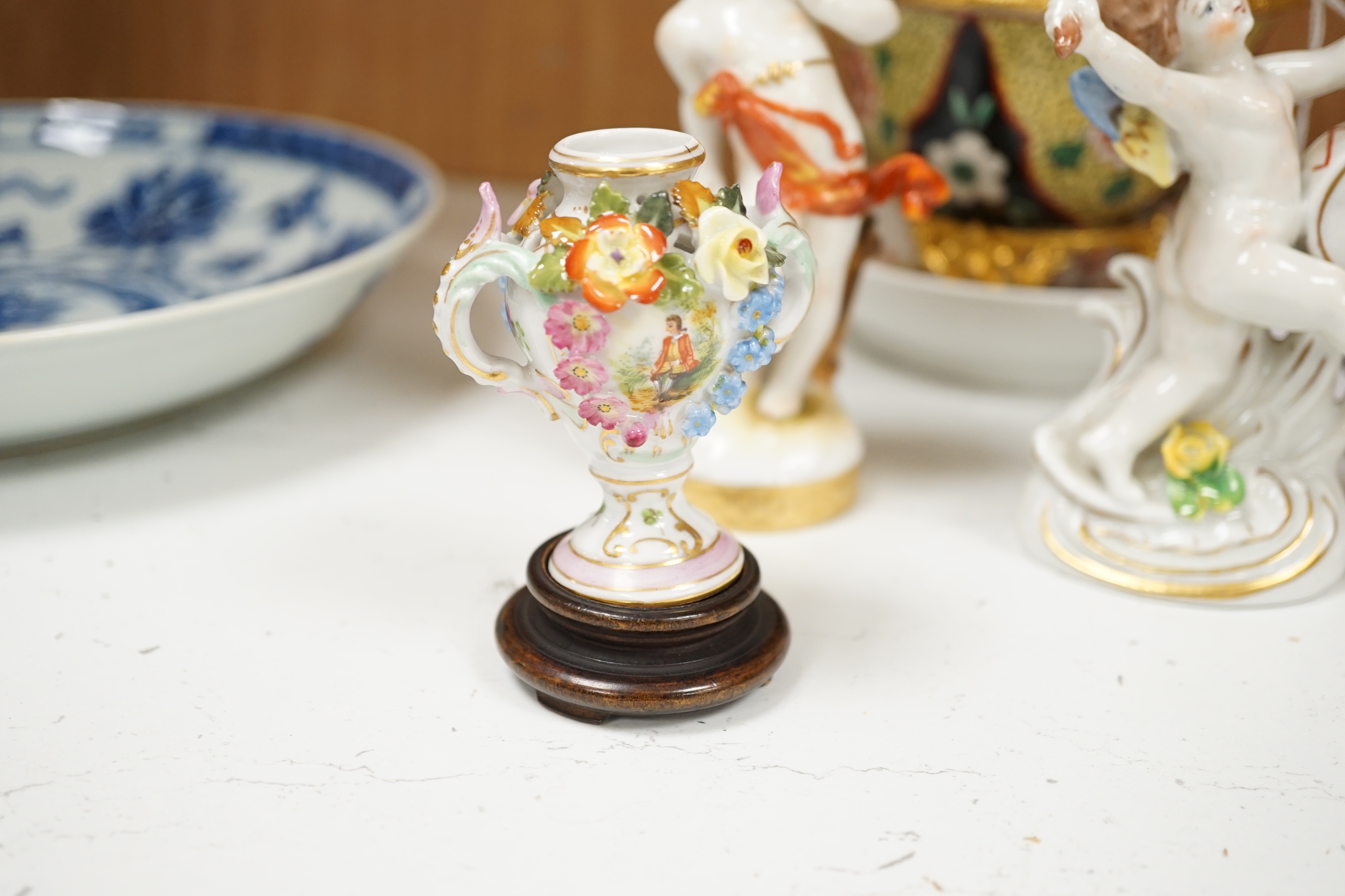 Continental porcelain: four putti ornaments, a Staffordshire dog, green leaf plate, a napkin ring 18th century jug etc (15)